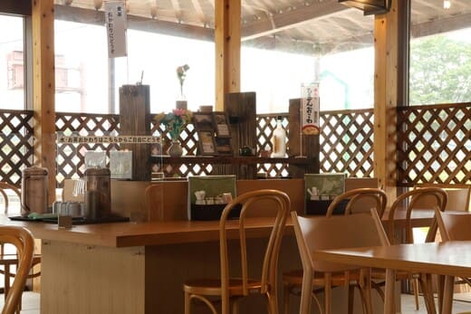 木製のテーブルと椅子が置かれたカフェの画像